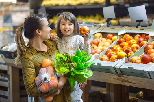 Une mère et sa fille au marché. Le chariot pliable, allié des familles urbaines